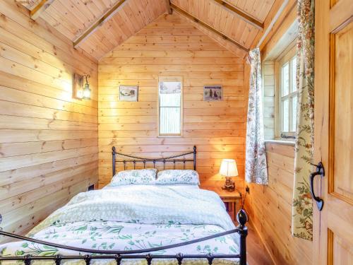 a bedroom with a bed in a log cabin at Bear House- Uk45704 in Brinkley