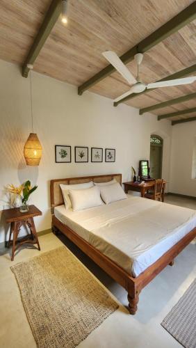 a bedroom with a large bed and a wooden ceiling at Sukomala Imaduwa in Ahangama