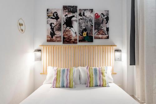 1 dormitorio con 1 cama con 4 cuadros en la pared en Charming Madrid Numancia, en Madrid