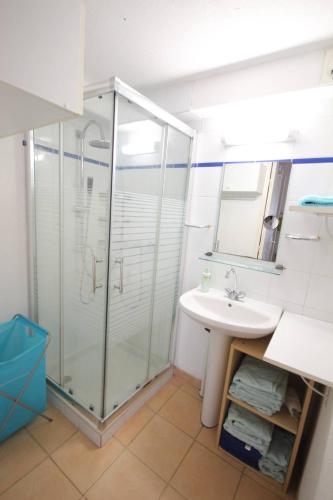 une salle de bain avec une douche en verre et un lavabo dans l'établissement Jolie Maison T3 mezzanine climatisée avec veranda, 4 à 5 couchages, terrasse clôturée, WIFI inclus, Résidence LES MARINES, 200m de la plage LRMA68B, à Portiragnes