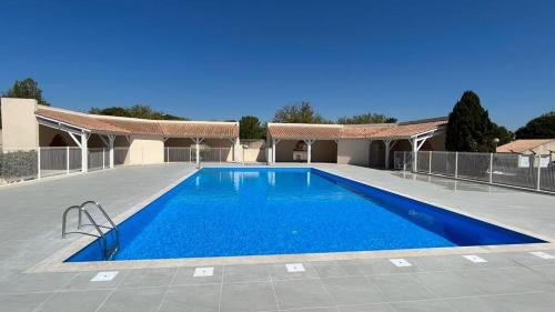 une grande piscine devant une maison dans l'établissement Jolie Maison T3 mezzanine climatisée avec veranda, 4 à 5 couchages, terrasse clôturée, WIFI inclus, Résidence LES MARINES, 200m de la plage LRMA68B, à Portiragnes