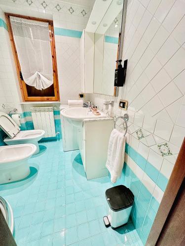 un bagno blu e bianco con due servizi igienici e un lavandino di The Flowers - Casa Calicanto a Roccaraso