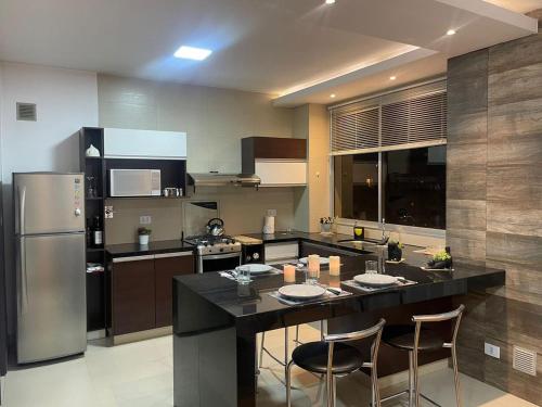 a kitchen with a large island in the middle at Hermoso Departamento En La Mejor Zona De Cochabamba in Cochabamba