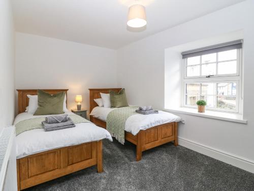 1 dormitorio con 2 camas y ventana en Y Cigydd en Derwen
