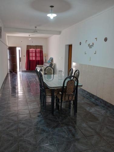 a dining room with a glass table and chairs at CASA CON COCHERA, HASTA 7 PERSONAS in Las Heras