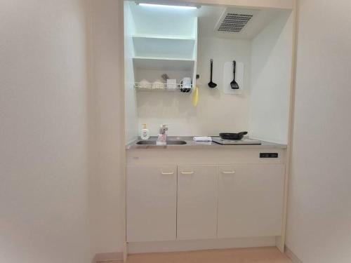 a white kitchen with a sink and a mirror at Dotonbori, Nipponbashi, Nagahoribashi Station 5minutes on foot Double bed SE7 in Osaka