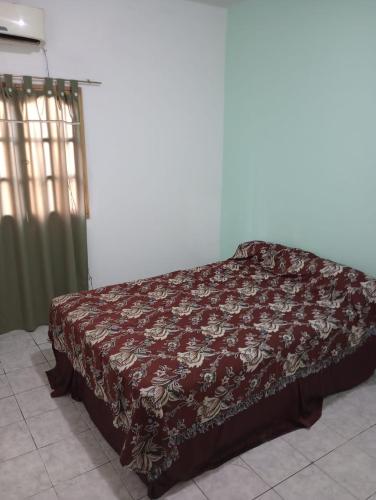 a bed in a room with a blanket on it at CASA CON COCHERA, HASTA 7 PERSONAS in Las Heras