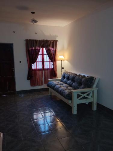 a couch in a living room with a window at CASA CON COCHERA, HASTA 7 PERSONAS in Las Heras