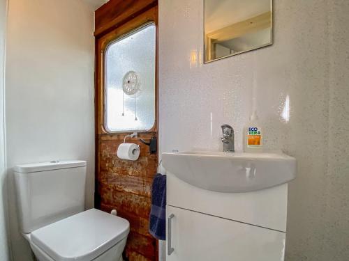 uma casa de banho com um lavatório branco e um WC. em Bessie - Uk45591 em Seend
