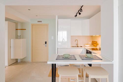 布加勒斯特的住宿－Vitan ApartHotel，白色的厨房配有桌子和两把椅子