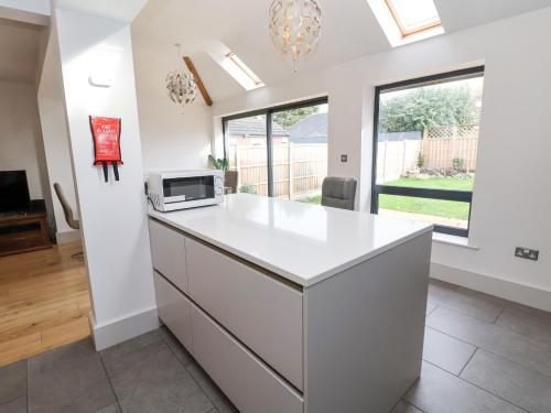 a kitchen with a white island with a microwave at Rainbows End in Chester