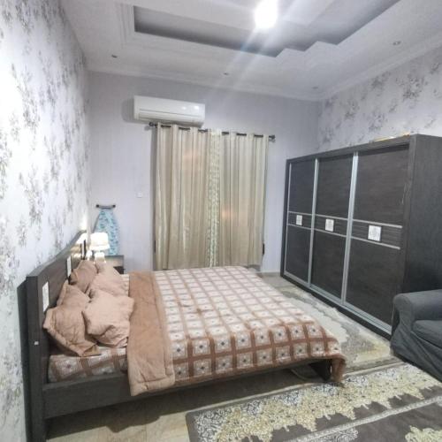 1 dormitorio con 1 cama grande en una habitación en العين الهيلي مصباح بيت 10, en Al Ain