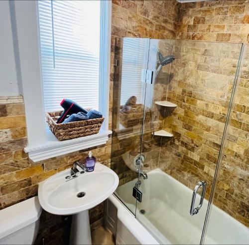 a bathroom with a shower and a sink and a tub at Cozy Home close to New York City in Fairview