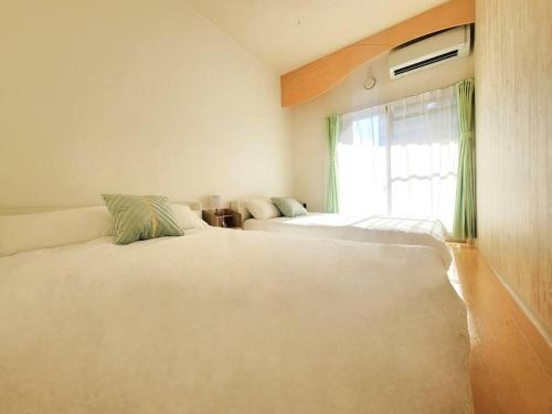 1 dormitorio con 2 camas y ventana en Dotonbori, Nipponbashi, Nagahoribashi Station 5minutes on foot Double bed SE3 en Osaka