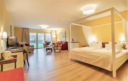 a hotel room with a large bed and a living room at Hotel Landhaus Ellerbrock in Sankt Peter-Ording