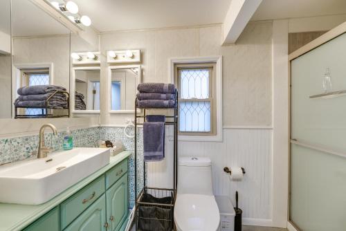 ein Badezimmer mit einem WC, einem Waschbecken und einem Spiegel in der Unterkunft All-Season Lakefront Reed City Home on 2 Acres! in Reed City