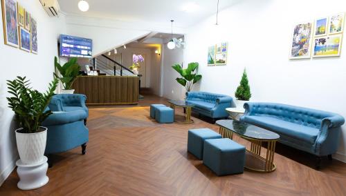 a waiting room with blue couches and tables at Covent Garden Hotel in Ho Chi Minh City