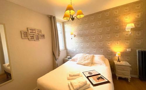 a small bedroom with a bed and a mirror at La Villa Les Mots Passants in Cabourg