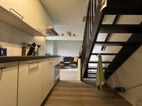 una cocina con una escalera que conduce a una sala de estar. en Stadslogement Goudsteeg 19B en Zwolle