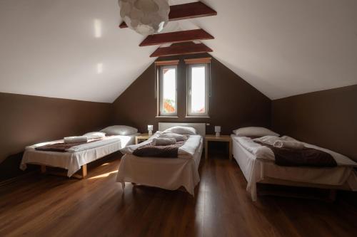 ジェロナ・グラにあるWilla Nataliaのベッド3台と窓が備わる客室です。