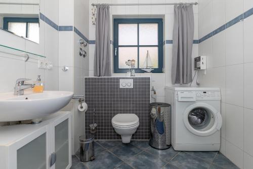 a bathroom with a sink and a washing machine at Apartments Büsumer Ring in Kühlungsborn
