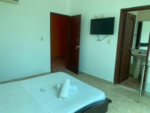 a room with a bed with a mirror and a television at Hotel Cascada Cristalina in Melgar