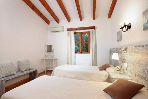 1 dormitorio con 2 camas y ventana en Villa Pedro Monjo, en Pollensa