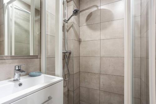La salle de bains est pourvue d'une douche et d'un lavabo. dans l'établissement Apartment center of Paris by Studio prestige, à Paris