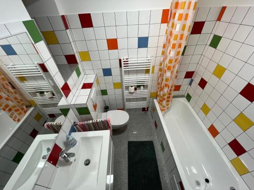 ein Badezimmer mit einer Badewanne, einem WC und einem Waschbecken in der Unterkunft Engstliz House in Foeni