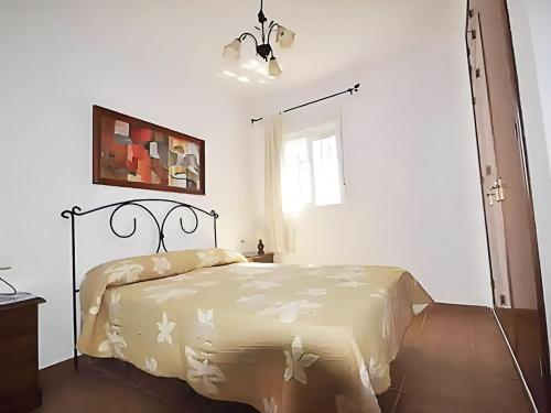 a bedroom with a bed in a white room at Casa Piscina Privada Jardín Barbacoa Tranquilo in Chiclana de la Frontera