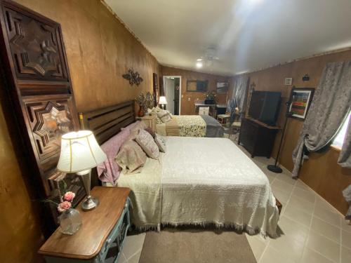 a bedroom with two beds and a lamp on a table at Hilda's Garage~Bandera, TX. in Bandera