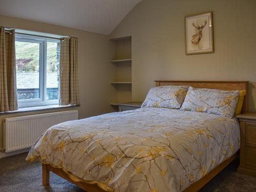 sypialnia z łóżkiem i oknem w obiekcie Striding Edge Cottage w mieście Glenridding
