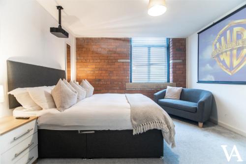 a bedroom with a large bed and a blue chair at Velvet Apartments - Conditioning House in Bradford