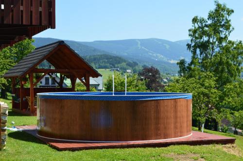 a large wooden pool with a gazebo at Penzion U pily in Paseky nad Jizerou
