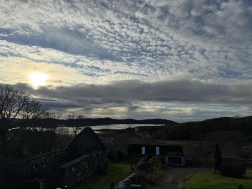a cloudy sky with a view of a lake at Victorian Chapel House in Arisaig