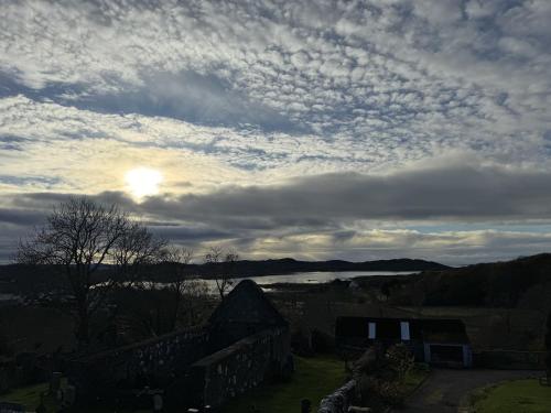 a cloudy sky with the sun in the background at Victorian Chapel House in Arisaig