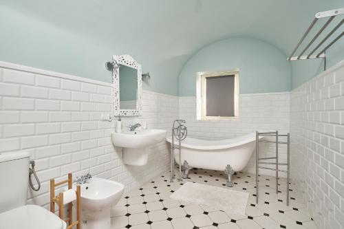 ein weißes Badezimmer mit einem Waschbecken, einer Badewanne und einem WC in der Unterkunft Apartament Empujon Sokołowsko in Sokołowsko