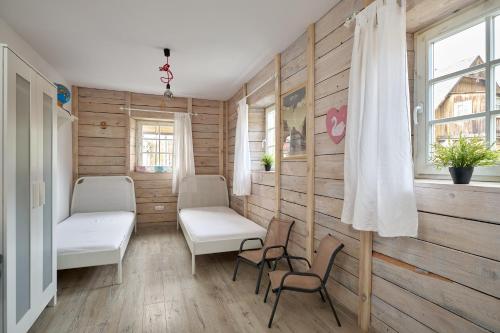 Sokołowsko的住宿－Apartament Empujon Sokołowsko，一间设有两把椅子、一张床和窗户的房间