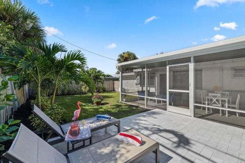 a house with a patio with a table and a bird on it at Paradise Palms House in Delray Beach