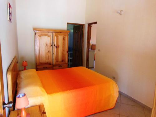 a bedroom with a bed with an orange bedspread at Casa Lily & Coco in Las Terrenas
