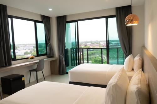 a hotel room with two beds and large windows at Mountain&Sea Hotel Prachuap in Prachuap Khiri Khan