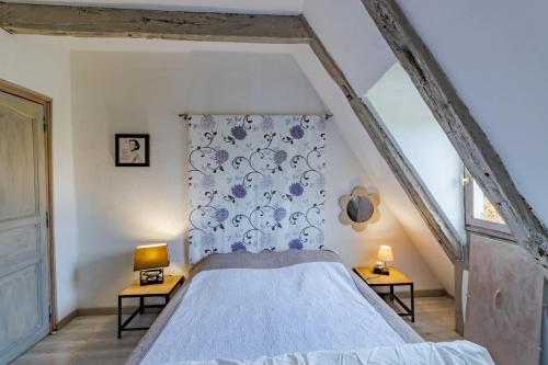 sypialnia z łóżkiem z niebiesko-białą narzutą w obiekcie Gite Castelnaud w mieście Sainte-Mondane