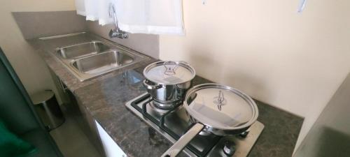a kitchen counter with two pans and a sink at Zwelibanzi Guesthouse in Johannesburg