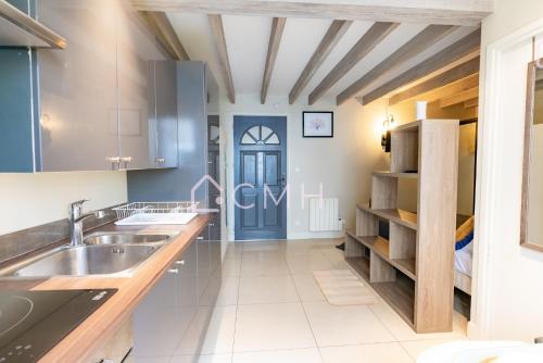 - une cuisine avec un évier et une porte bleue dans l'établissement Studio cozy proche de l’aéroport CDG, à Le Thillay