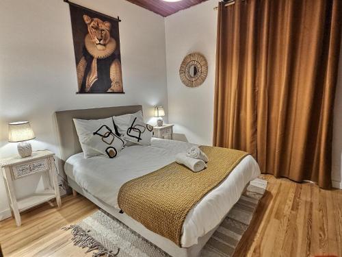 Un dormitorio con una cama con una foto de un león en Gîte de l'Adour, Rénové & Chic, Parking, en Gerde