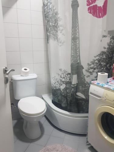 uma casa de banho com um WC e uma cortina de chuveiro com a torre Eiffel em ONE bedroom apartment - close the CITY CENTER! PRISHTINA em Pristina