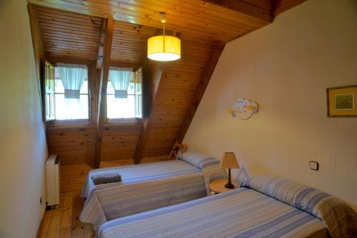 a room with three beds in a log cabin at La Casita de la Sierra Cercedilla in Cercedilla