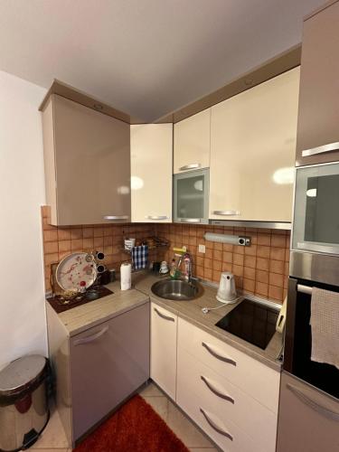 a kitchen with white cabinets and a sink at Bjelasnica Apartment with the most beautiful view in Bjelašnica