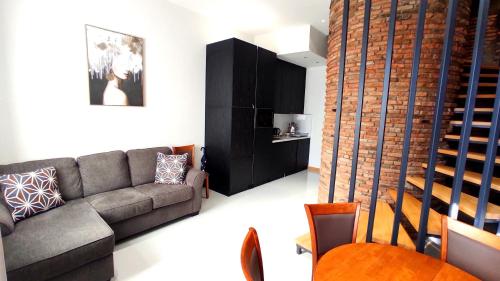 a living room with a couch and a staircase at Apart Hotel Banovani in Tbilisi City