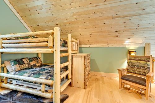 a bedroom with two bunk beds in a log cabin at Modern Cabin with Hot Tub and Sacandaga Lake Access! in Broadalbin